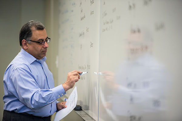 A SAIT instructor writes on a whiteboard.