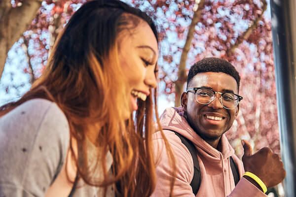 Two people sitting outside looking left of the camera