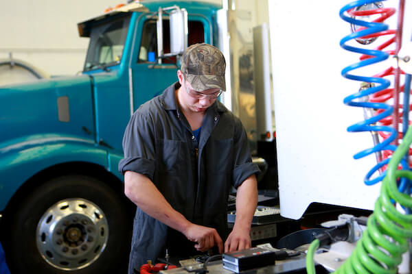 A student focused on fixing a box on a work bench